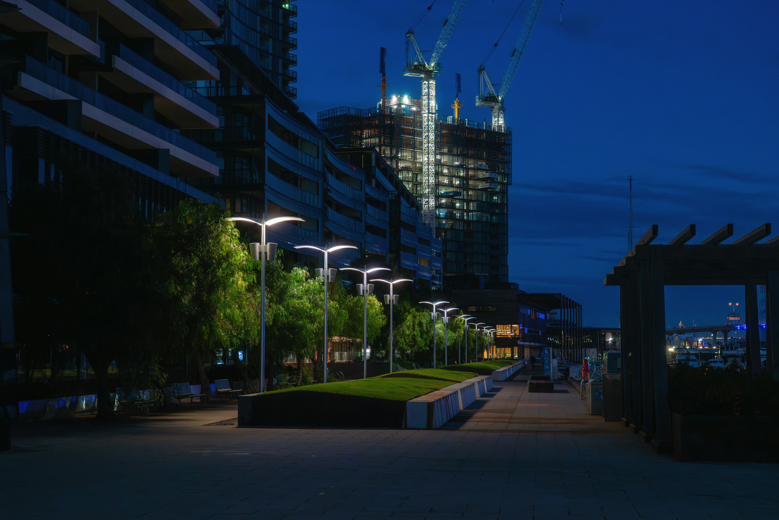 Construction cranes rising over a city skyline at dusk